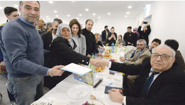 Ayaz Erdem 60 yıllık eşi Mahizer’e kitabını imzalayarak hediye etti (tokalaşanlar). Fotoğrafta sol başta Ogün Erdem ve eşi Nuran Erdem (soldan sağ üçüncü sırada).